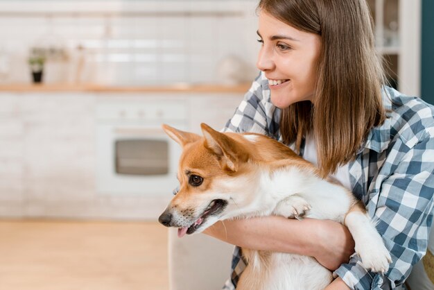 Vista lateral del perro retenido por una mujer