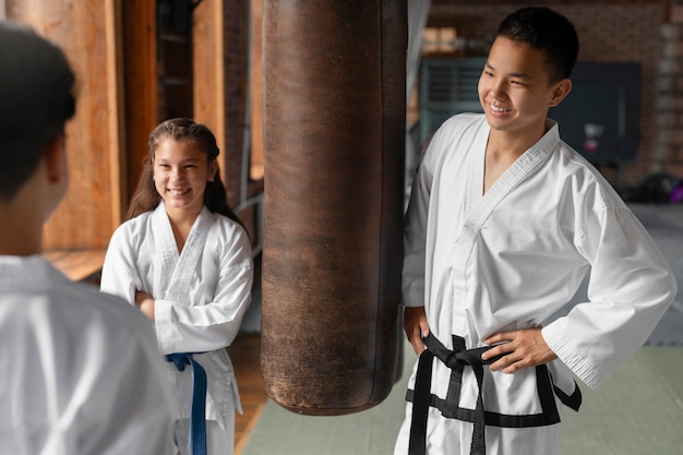 Foto gratuita vista lateral de personas asiáticas practicando taekwondo