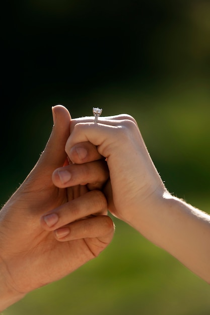 Vista lateral de personas comprometidas tomados de la mano