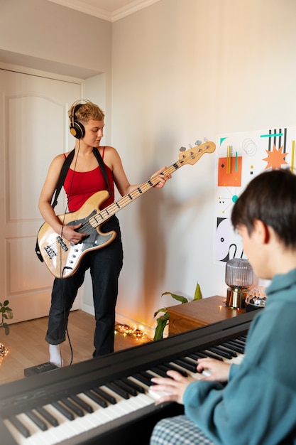 Foto gratuita vista lateral de personas haciendo música en casa.