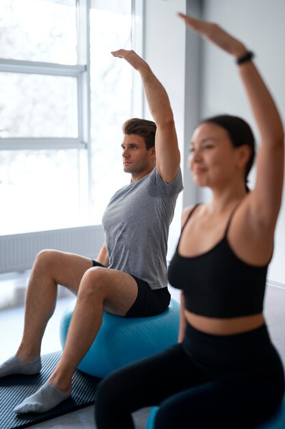 Vista lateral de personas haciendo pilates