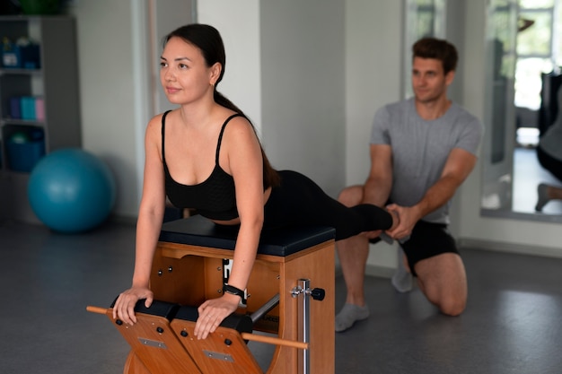 Vista lateral de personas haciendo pilates