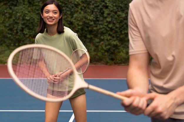 Foto gratuita vista lateral de personas jugando al bádminton juntos