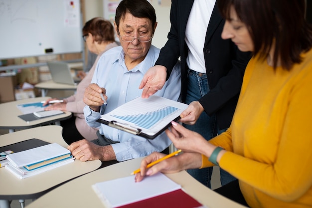 Foto gratuita vista lateral de personas mayores aprendiendo juntas