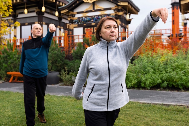 Foto gratuita vista lateral de personas practicando tai chi afuera