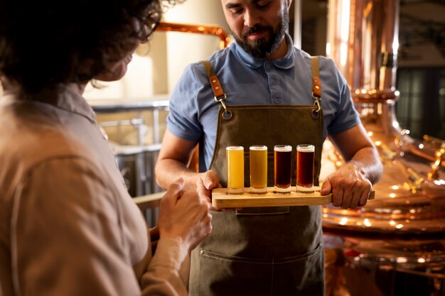 Vista lateral de personas que trabajan en la fábrica de cerveza.