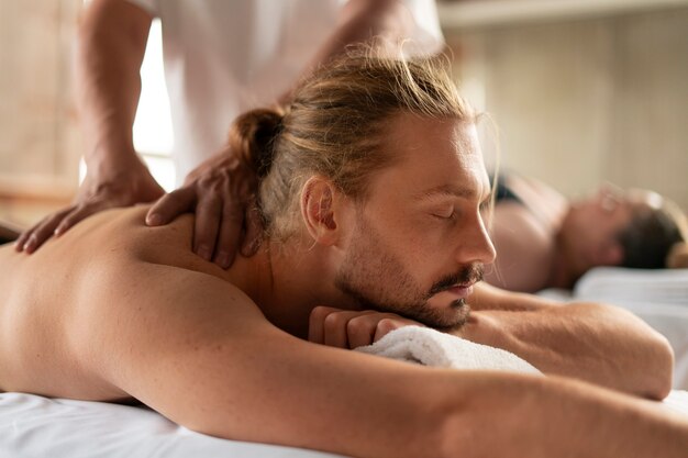 Vista lateral de personas recibiendo un masaje