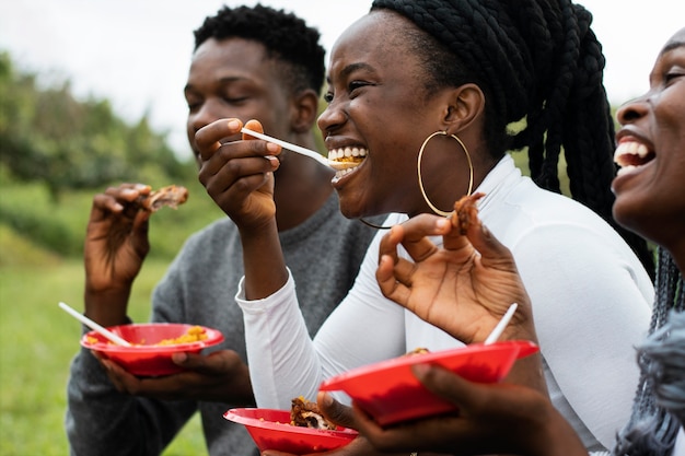 Foto gratuita vista lateral de personas sonrientes con comida deliciosa
