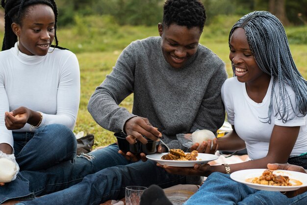 Vista lateral de personas sonrientes con comida deliciosa