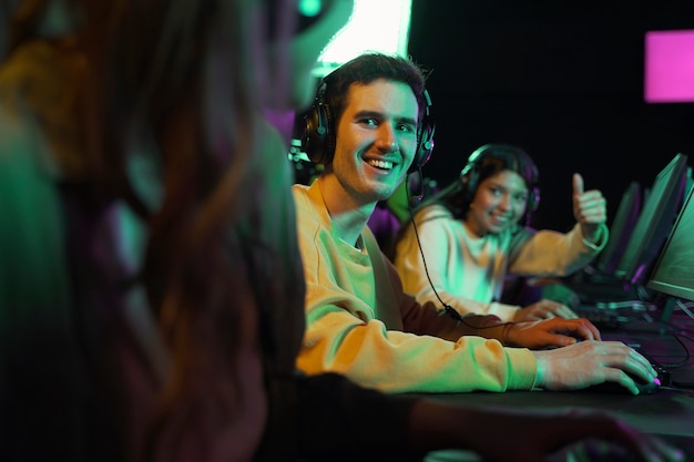 Vista lateral de personas sonrientes jugando videojuegos