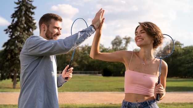 Foto gratuita vista lateral de personas sonrientes con raquetas