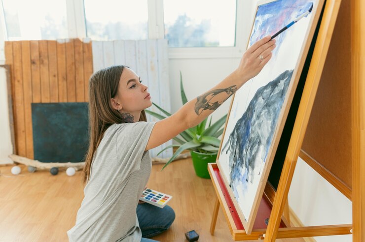 Foto gratuito vista lateral de la pintura femenina y su obra.