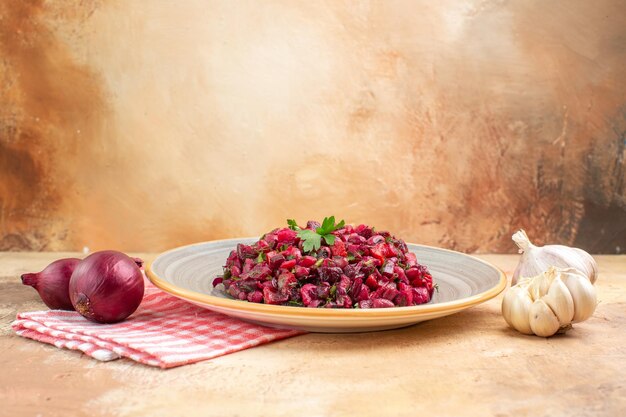 Vista lateral del plato de una ensalada roja con verduras sobre un fondo de madera