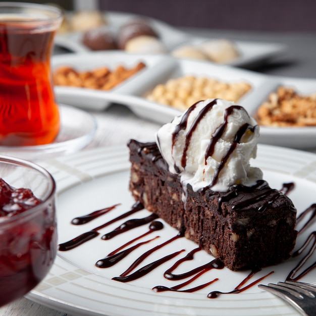 Foto gratuita vista lateral postre en placa con té, nueces, mermelada de frutas sobre fondo blanco de madera.