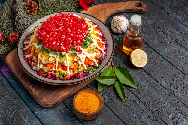 Vista lateral de primer plano alimentos y ramas Plato de Navidad en la tabla de cortar junto a la botella de aceite ramas de abeto con conos ajo limón tazón de especias