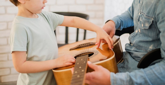 Foto gratuita vista lateral del profesor de guitarra y niño