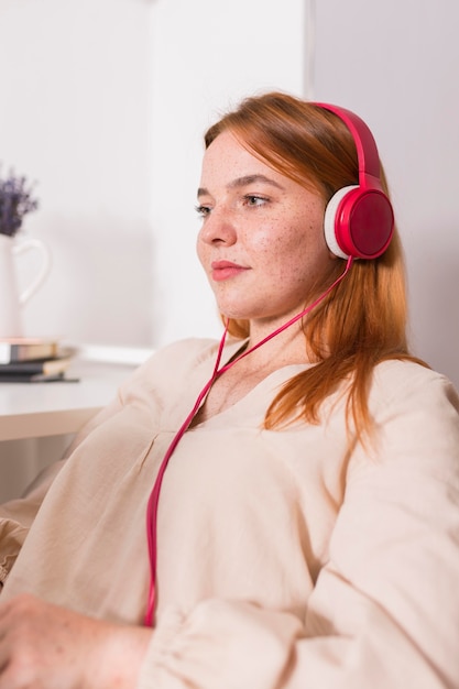 Vista lateral de la profesora con auriculares durante la clase en línea