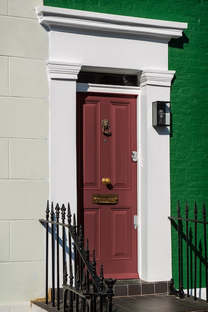 Foto gratuita vista lateral de la puerta delantera con pared beige y verde