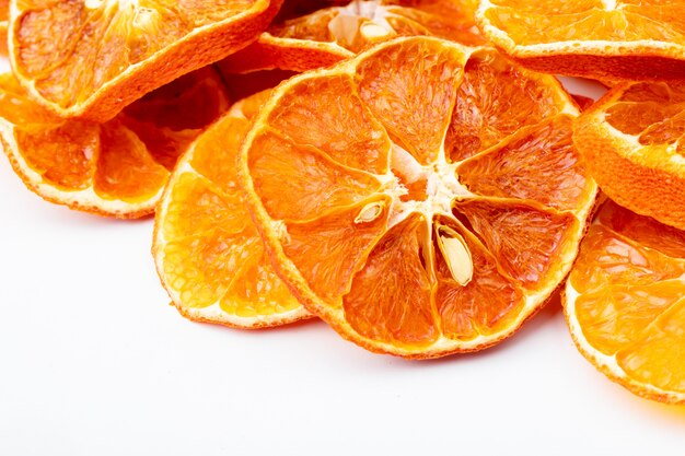 Vista lateral de rodajas de naranja secas aisladas sobre fondo blanco.
