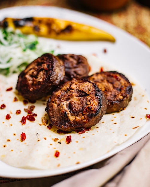 Foto gratuita vista lateral del rollo de carne a la parrilla sobre pan de pita con cebolla