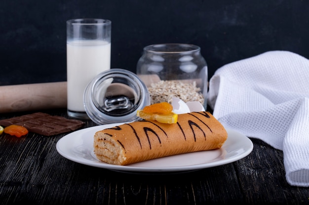 Foto gratuita vista lateral del rollo suizo con mermelada de albaricoque en un plato blanco