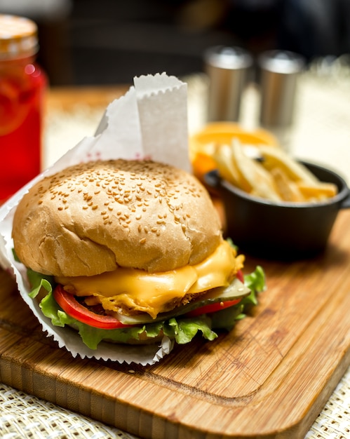 Vista lateral sandwich de queso y papas fritas en el tablero