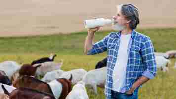 Foto gratuita vista lateral senior bebiendo leche de cabra