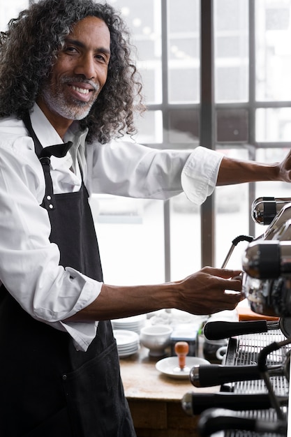 Vista lateral sonriente hombre haciendo café