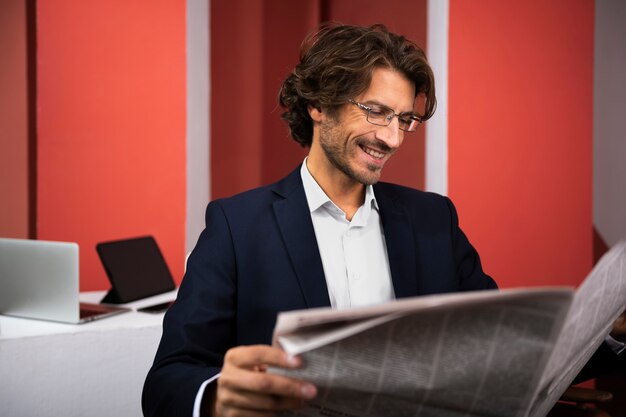 Vista lateral sonriente hombre leyendo periódico