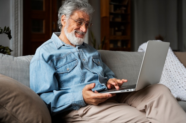 Vista lateral sonriente hombre sosteniendo laptop