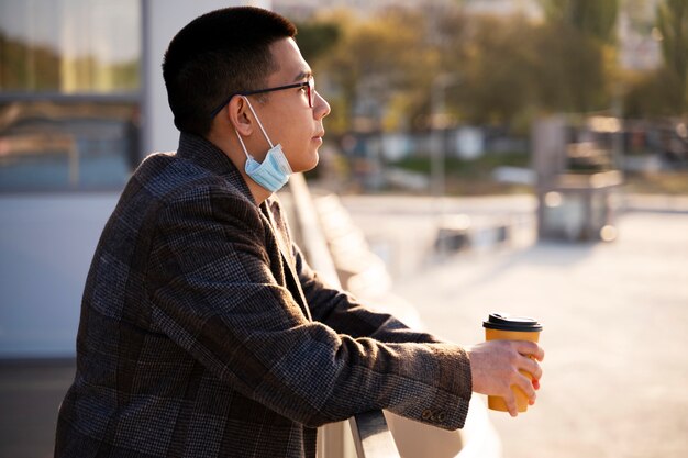 Foto gratuita vista lateral sonriente hombre sosteniendo taza de café