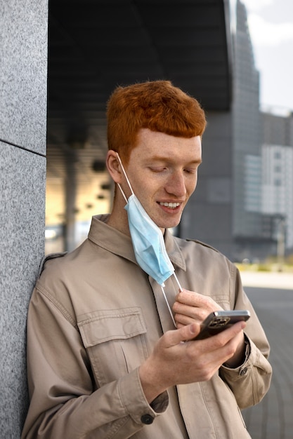 Vista lateral sonriente hombre con teléfono inteligente