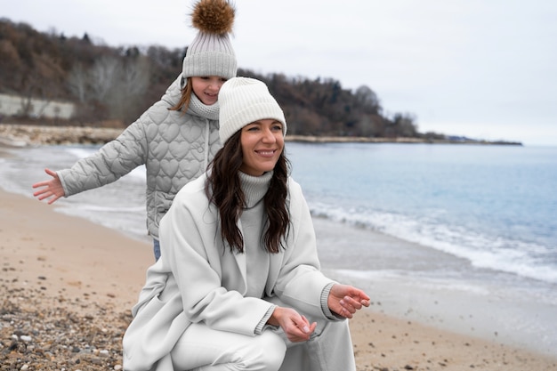 Foto gratuita vista lateral sonriente madre y niño en la playa