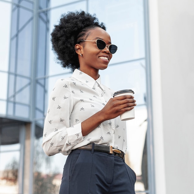 Vista lateral sonriente mujer con café al aire libre