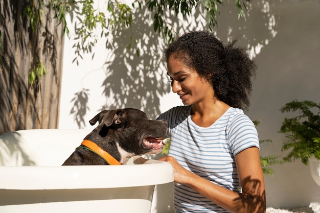 Foto gratuita vista lateral sonriente mujer lavando perro