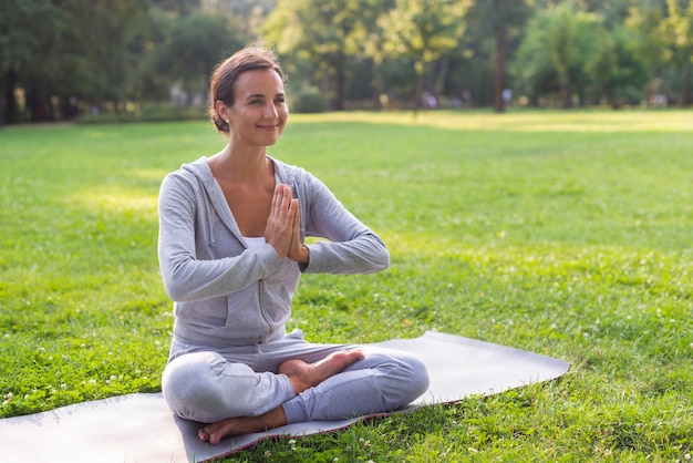 Vista lateral sonriente mujer meditando pose