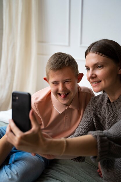 Vista lateral sonriente mujer y niño tomando selfie