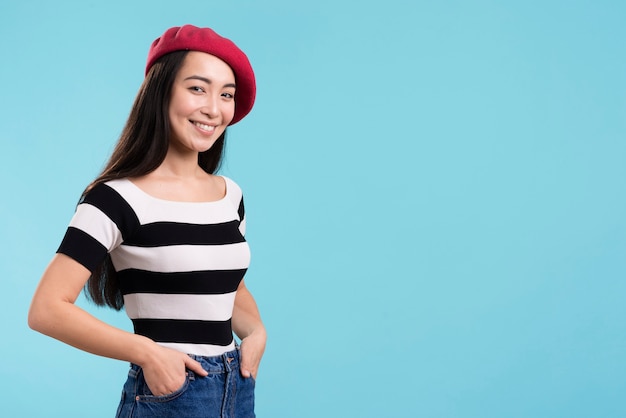 Vista lateral sonriente mujer con sombrero rojo