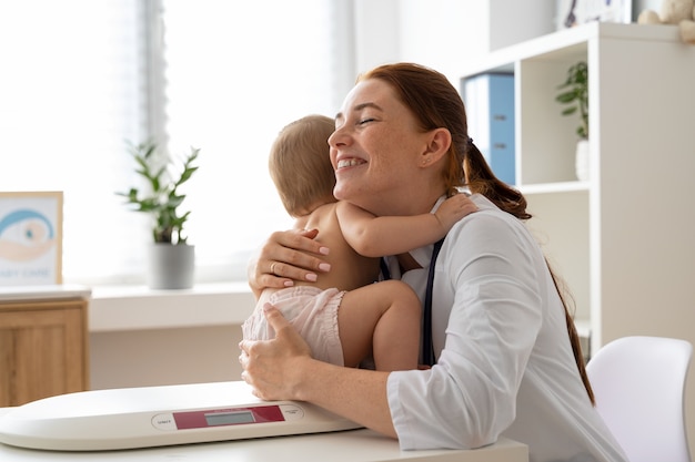 Foto gratuita vista lateral sonriente mujer sosteniendo bebé