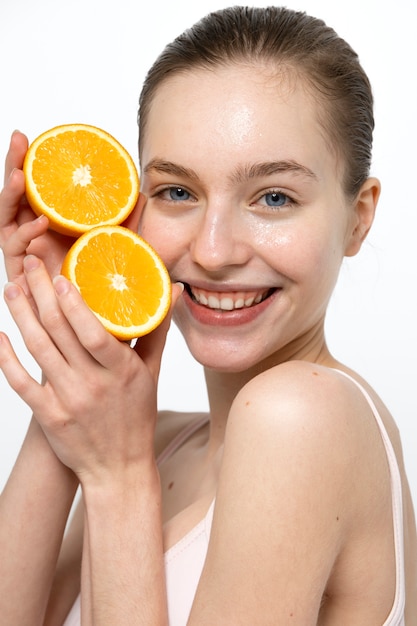 Vista lateral sonriente mujer sosteniendo naranja