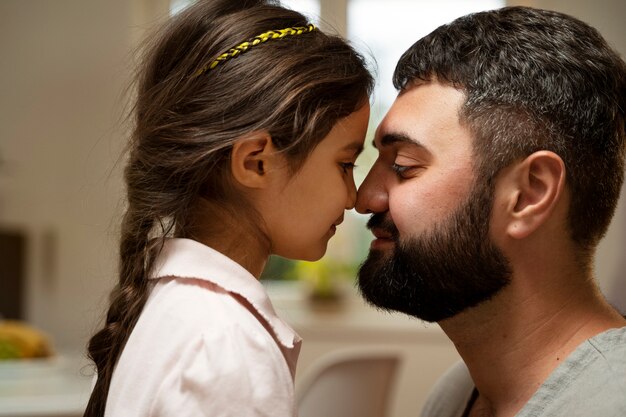 Vista lateral sonriente padre y niña