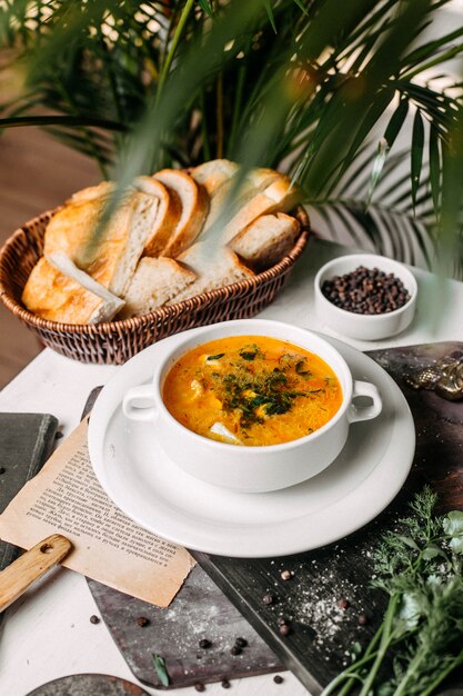 Vista lateral de sopa con coliflor y papas en un tazón blanco