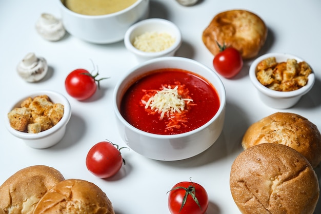Foto gratuita vista lateral sopa de tomate con crutones de queso tomate y pan
