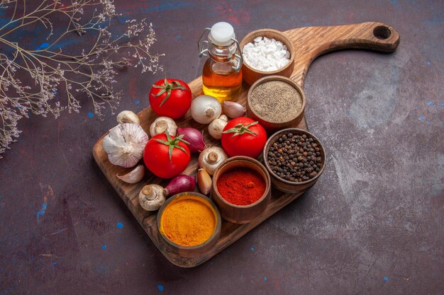 Vista lateral superior especias en el tablero diferentes especias tomates champiñones cebolla y aceite en la tabla de cortar