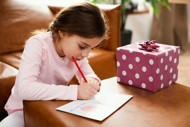 Vista lateral de la tarjeta de dibujo de la hija para el día del padre con presente