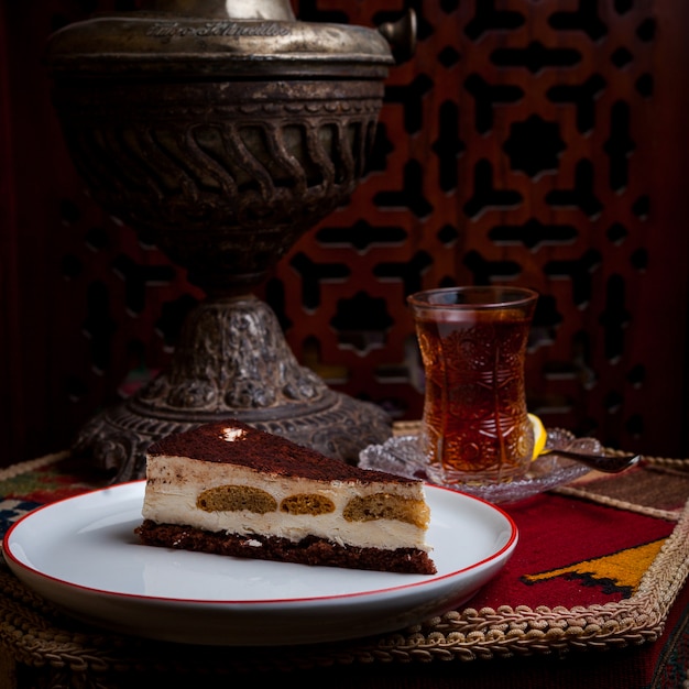 Foto gratuita vista lateral tarta de queso con vaso de té en la mesa