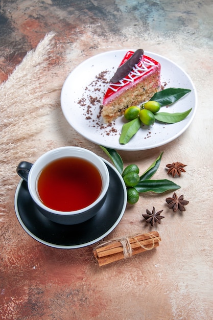 Vista lateral de una taza de té negro taza de té canela anís estrellado plato de pastel