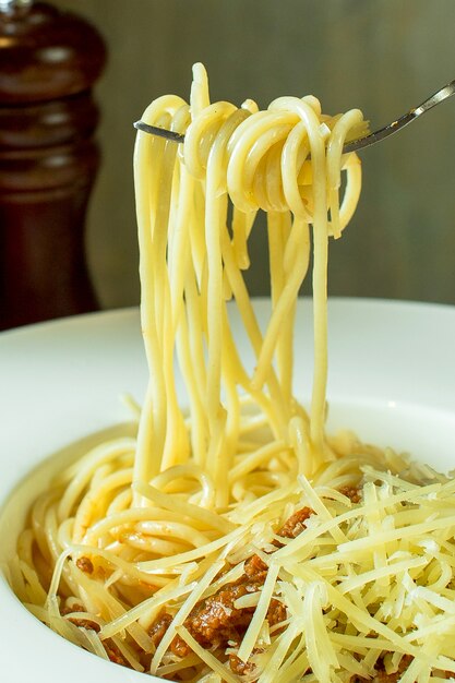 Vista lateral del tenedor con espagueti alrededor