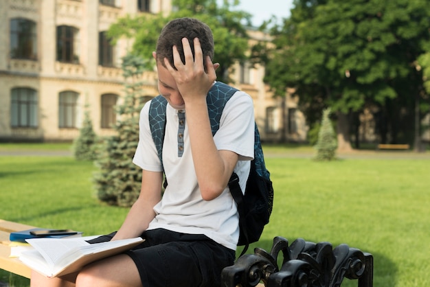 Foto gratuita vista lateral tiro medio abrumado adolescente leyendo