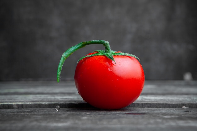 Foto gratuita vista lateral de tomate sobre fondo oscuro de madera y textura. horizontal